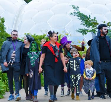 Families dressed up in Halloween costumes walking at the Eden Project